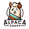 Logo of Alpaca Soaps, featuring an adorable, smiling alpaca with a flower behind its ear, peeking over a colorful, geometric-patterned blanket. The company name 'Alpaca Soaps' is written below in stylized, friendly lettering