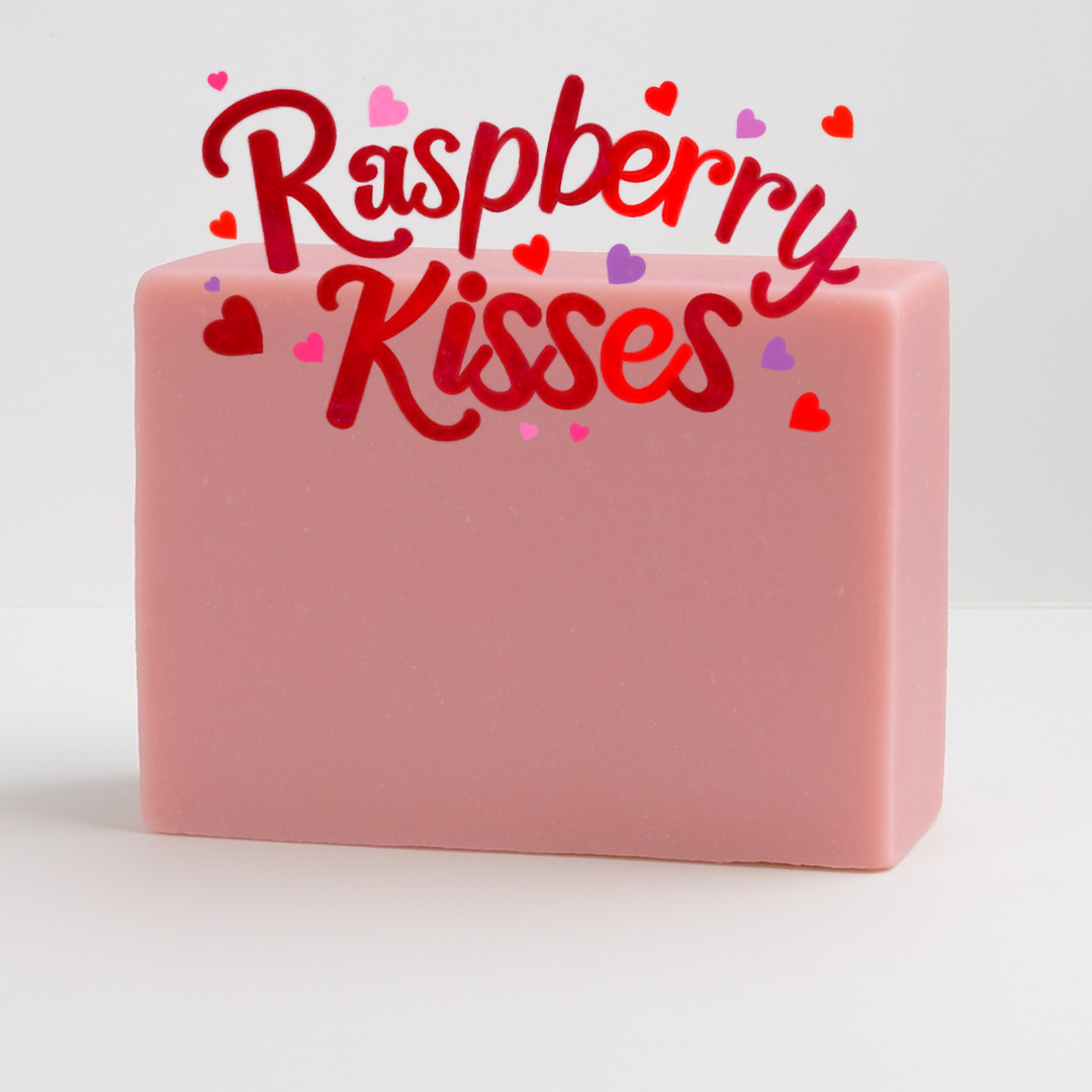 Pink soap bar with 'Raspberry Kisses' text and heart shapes on a white background