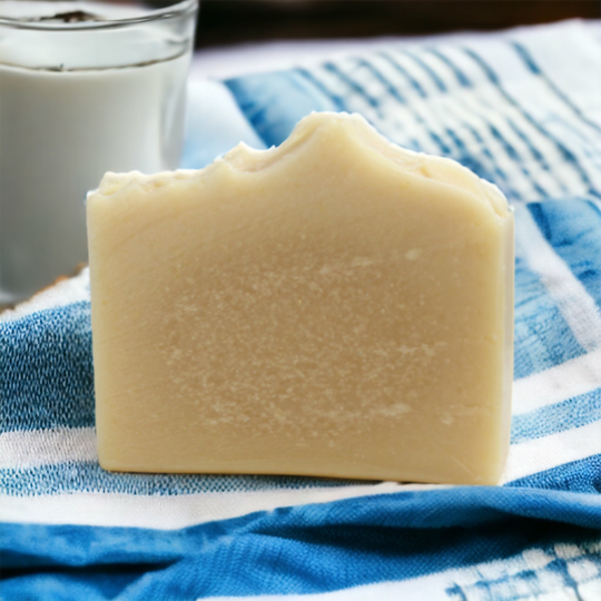 Goat's MIlk Soap on a woven blue tea towel with a glass of milk in the background Alpaca Soaps AlpacaSoaps