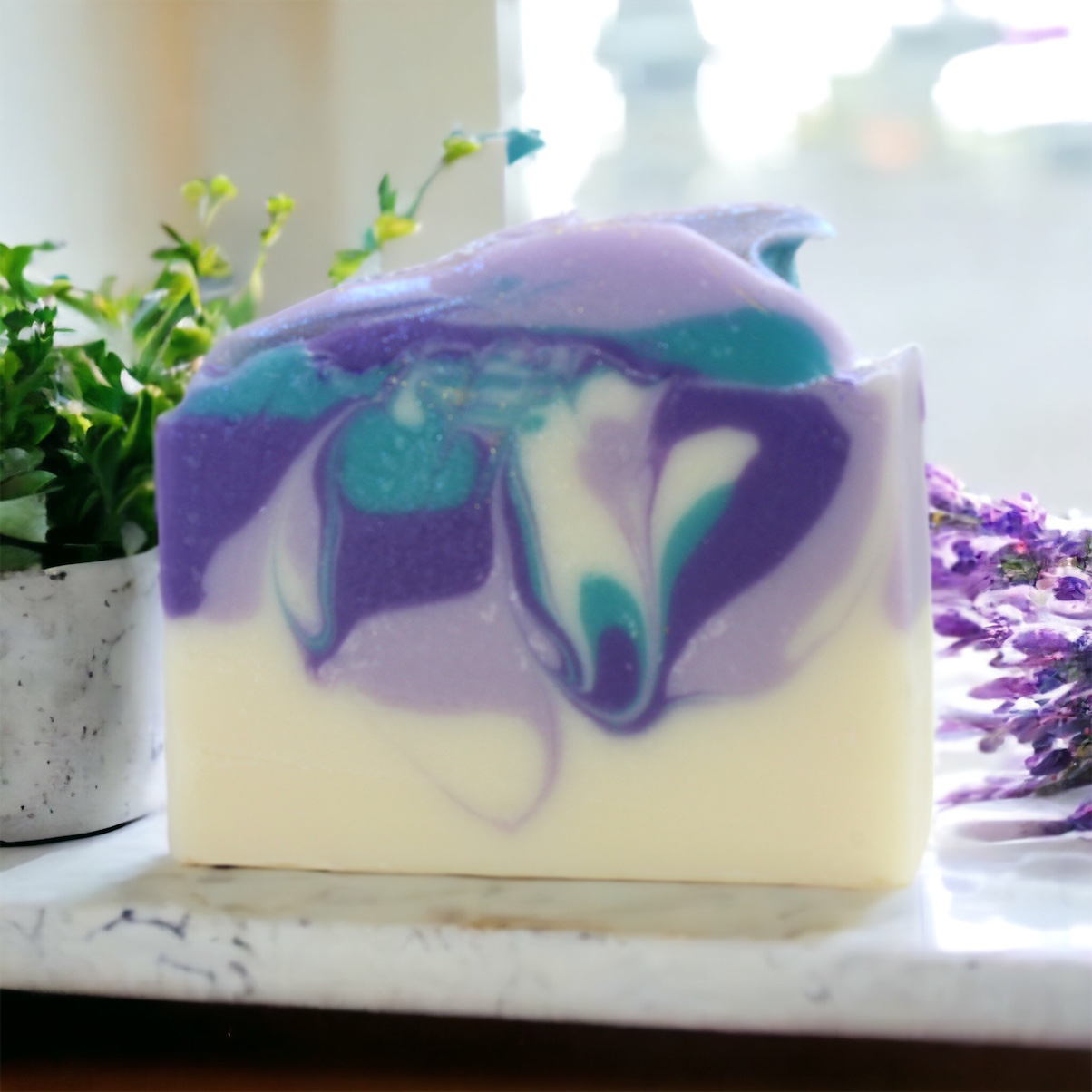 Lavender Bar soap on a marble counter with a potted plant and lavender bunch in the background Alpaca Soaps AlpacaSoaps
