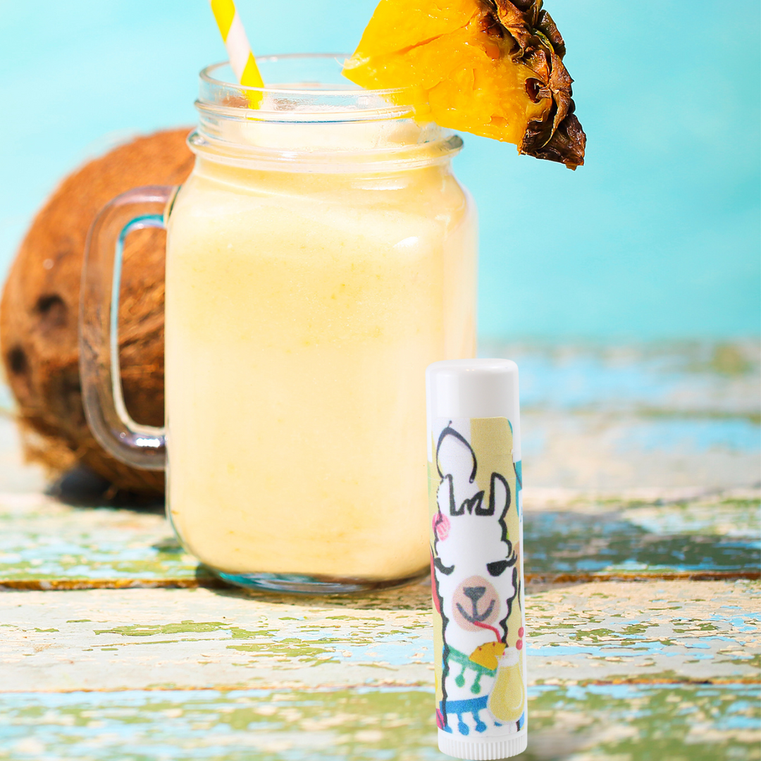  Pina Colada Flavored Lip Balm in photo with a Pina Colada cocktail Alpaca Soaps, AlpacaSoaps
