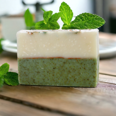 Rosemary Mint Bar Soap on rustic wooden tabletop with fresh mint leaves in the background, Alpaca Soaps AlpacaSoaps