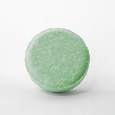 a close up of a green bath bomb on a white background