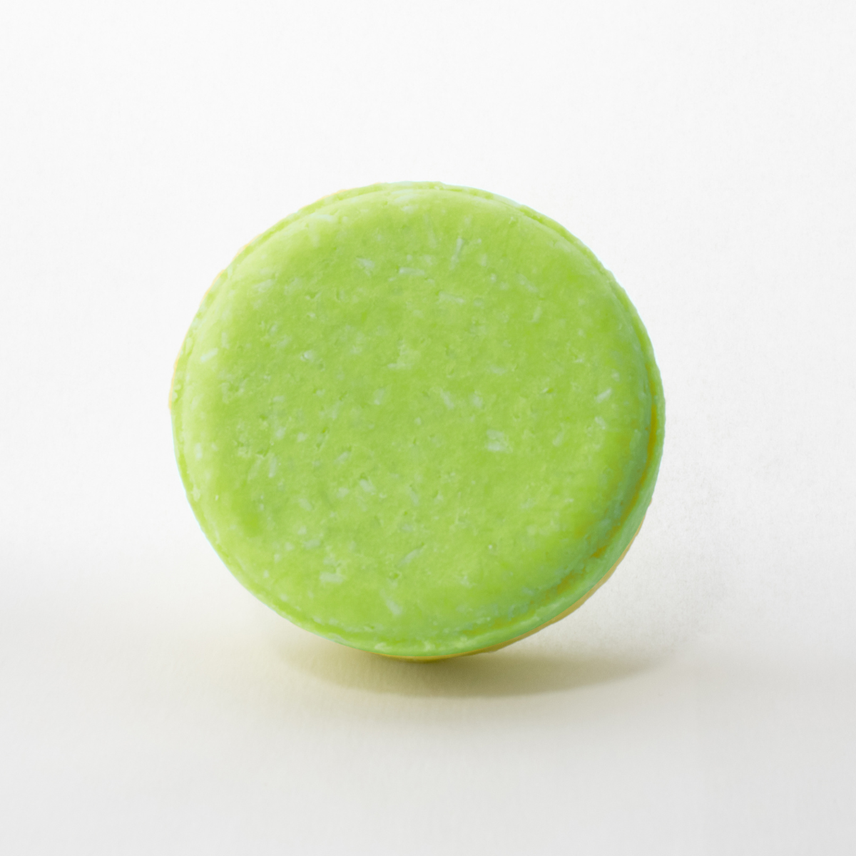 a close up of a green round object on a white surface