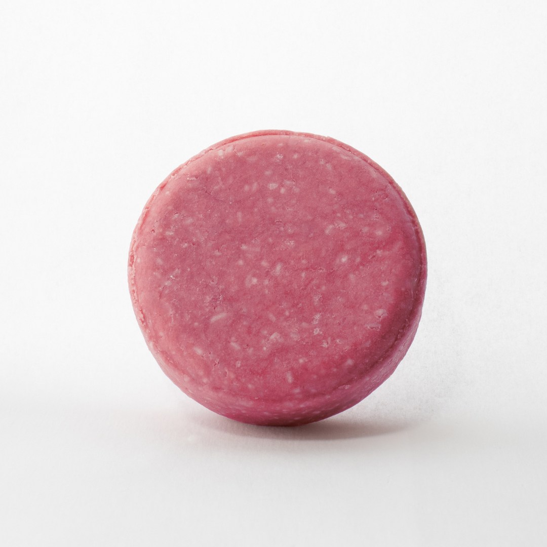 a close up of a pink round object on a white background