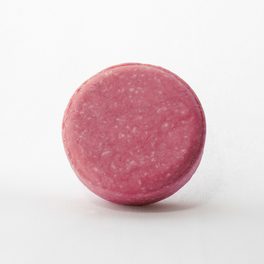 a close up of a pink round object on a white background