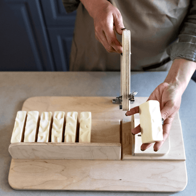 Cutting cream-colored soap with a single wire cutter. Alpaca Soaps AlpacaSoaps